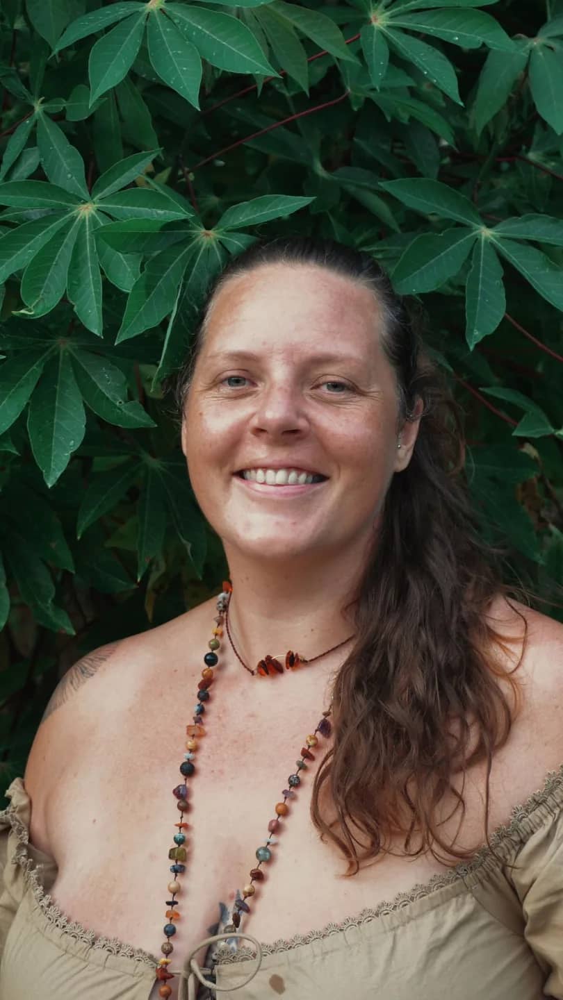 Harriet Daisy Trower smiling under cassava leaves